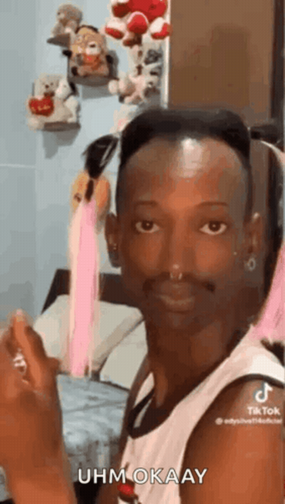 A Man With A Beard And A Nose Ring Is Sitting In A Bedroom . GIF