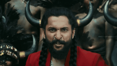 A Man With A Beard And A Nose Ring Is Standing In Front Of A Group Of People With Horns GIF