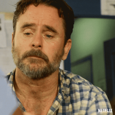 A Man With A Beard And A Plaid Shirt Has A Netflix Logo On His Shirt GIF