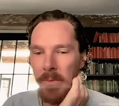 A Man With A Beard And A Ring On His Finger Is Looking At The Camera . GIF