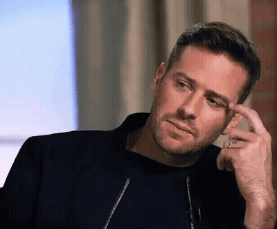 A Man With A Beard And A Ring On His Finger Is Looking At The Camera . GIF
