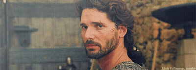 A Man With A Beard And A Scar On His Face Is Looking Over His Shoulder At Something GIF
