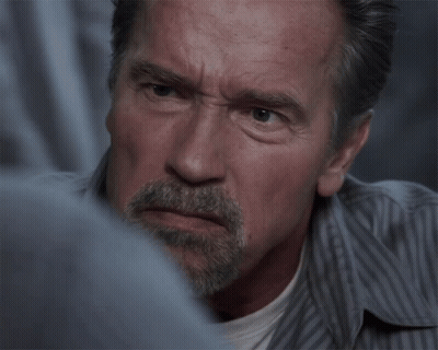 A Man With A Beard And A Striped Shirt Looks Angry GIF