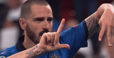 A Man With A Beard And A Tattoo On His Arm Is Making A Funny Face With His Hands . GIF