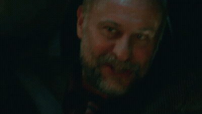 A Man With A Beard And A Tattoo On His Arm Is Smiling And Holding His Hand To His Face . GIF