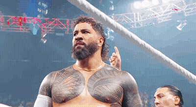A Man With A Beard And A Tattoo On His Chest Is Standing In A Ring . GIF