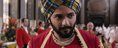 A Man With A Beard And A Turban Is Standing In Front Of A Crowd Of People . GIF