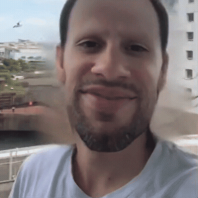 A Man With A Beard And A White Shirt Is Smiling GIF