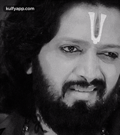 A Man With A Beard And A White U On His Forehead Is Making A Funny Face . GIF