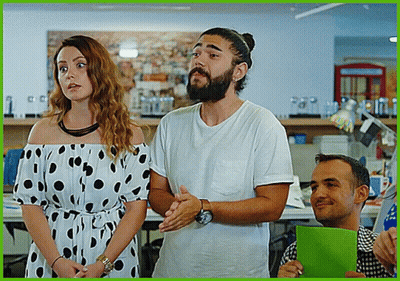 A Man With A Beard And A Woman In A Polka Dot Dress Are Standing Next To Each Other GIF