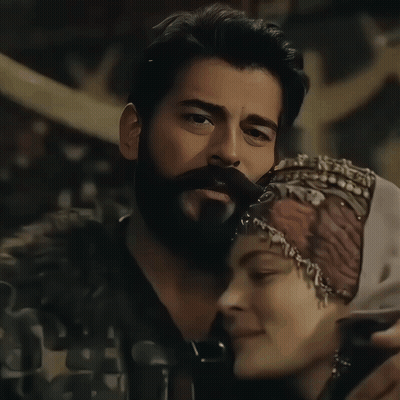 A Man With A Beard And A Woman Wearing A Head Scarf GIF
