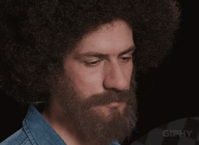 A Man With A Beard And An Afro Looks At The Camera With The Word Giphy Below Him GIF