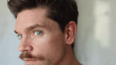 A Man With A Beard And Blue Eyes Is Looking At The Camera GIF