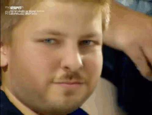 A Man With A Beard And Blue Eyes Is Making A Funny Face . GIF