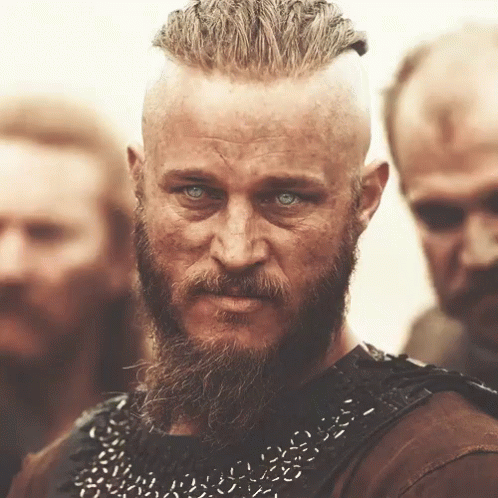 A Man With A Beard And Blue Eyes Stands In A Crowd GIF