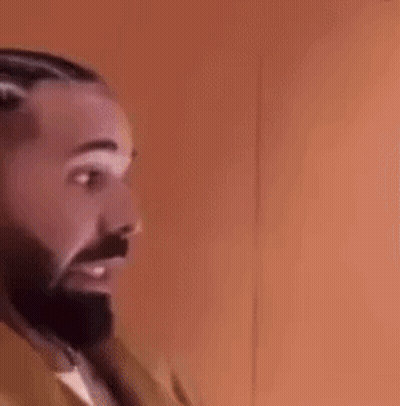 A Man With A Beard And Braids Is Wearing Earrings And A Jacket . GIF
