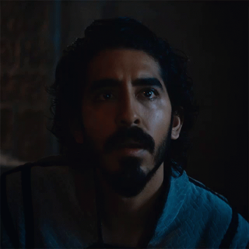 A Man With A Beard And Curly Hair Looks Up Into The Dark GIF