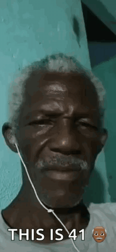 A Man With A Beard And Ear Buds Is Wearing Headphones . GIF