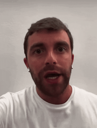 A Man With A Beard And Earrings Is Wearing A White Shirt GIF
