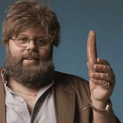 A Man With A Beard And Glasses Is Holding A Sausage In His Hand GIF