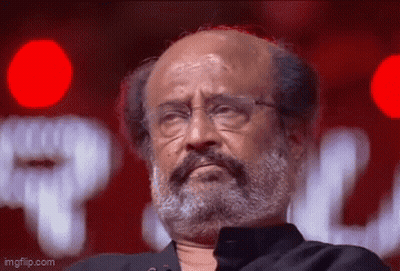 A Man With A Beard And Glasses Is Looking At The Camera . GIF