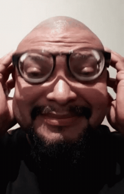 A Man With A Beard And Glasses Is Making A Funny Face GIF