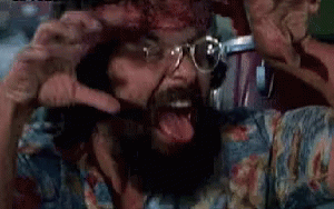 A Man With A Beard And Glasses Is Screaming And Making A Funny Face . GIF