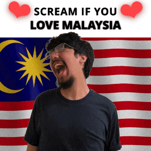 A Man With A Beard And Glasses Is Screaming In Front Of A Malaysian Flag GIF
