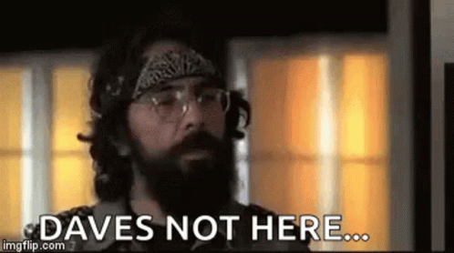A Man With A Beard And Glasses Is Standing In Front Of A Window And Saying `` Daves Not Here ... '' . GIF