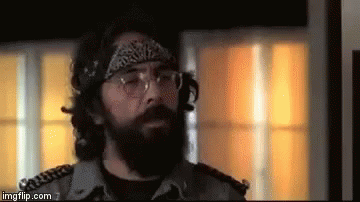 A Man With A Beard And Glasses Is Wearing A Bandana And Headphones . GIF