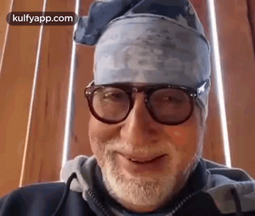 A Man With A Beard And Glasses Is Wearing A Bandana And Smiling . GIF