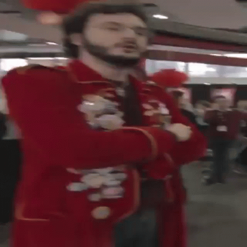 A Man With A Beard And Glasses Is Wearing A Red Jacket GIF