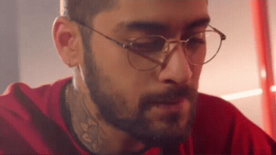 A Man With A Beard And Glasses Is Wearing A Red Shirt And A Red Shirt . GIF