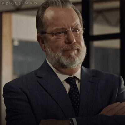 A Man With A Beard And Glasses Is Wearing A Suit And Tie With The Hashtag #Diggstown GIF