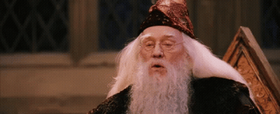 A Man With A Beard And Glasses Is Wearing A Wizard Hat GIF