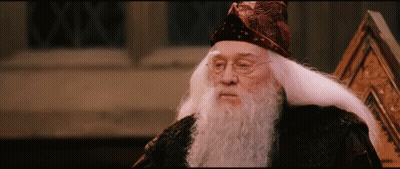 A Man With A Beard And Glasses Is Wearing A Wizard Hat GIF