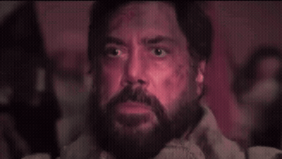A Man With A Beard And Glowing Eyes Is Looking Up At Something . GIF