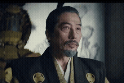A Man With A Beard And Mohawk Is Wearing A Samurai Costume And Looking At The Camera . GIF
