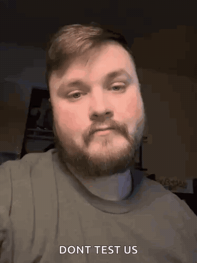 A Man With A Beard And Mustache Is Making A Funny Face And Says Do N't Test Us . GIF