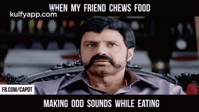 A Man With A Beard And Mustache Is Sitting In A Chair . GIF
