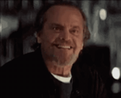 A Man With A Beard And Mustache Is Smiling And Looking At The Camera . GIF