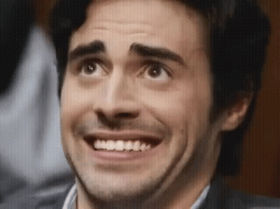 A Man With A Beard And Mustache Is Smiling And Looking Up . GIF