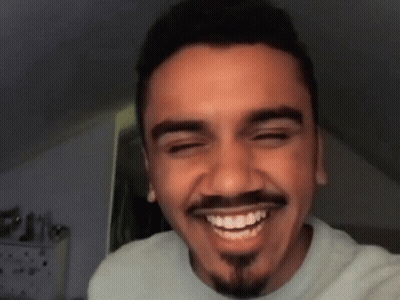 A Man With A Beard And Mustache Is Smiling GIF