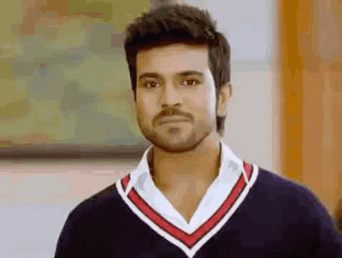 A Man With A Beard And Mustache Is Wearing A Black Sweater And A White Shirt . GIF