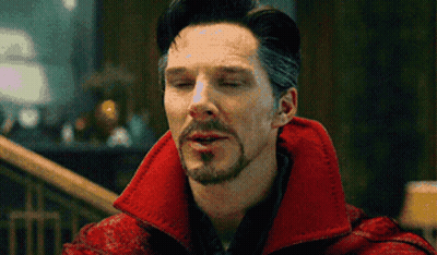 A Man With A Beard And Mustache Is Wearing A Red Coat And Making A Funny Face With His Eyes Closed . GIF