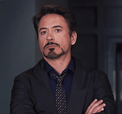 A Man With A Beard And Mustache Wearing A Black Jacket And Tie GIF