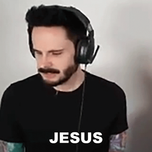 A Man With A Beard And Mustache Wearing Headphones And A Black Shirt With The Word Jesus On It . GIF