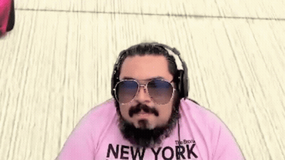 A Man With A Beard And Mustache Wearing Sunglasses And Headphones Is Wearing A Pink Shirt That Says New York . GIF