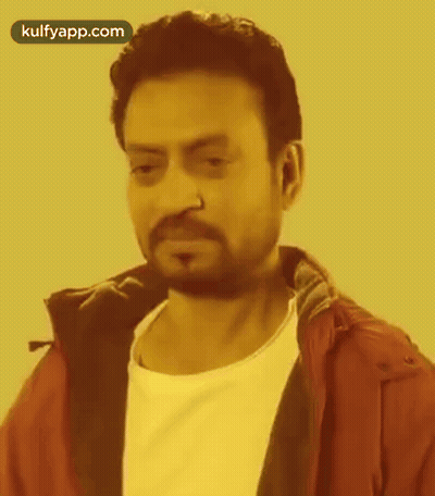 A Man With A Beard And Nose Ring Is Wearing A Red Jacket And White Shirt . GIF