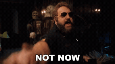 A Man With A Beard And Sunglasses Is Pointing At The Camera With The Words `` Not Now '' Written Next To Him . GIF